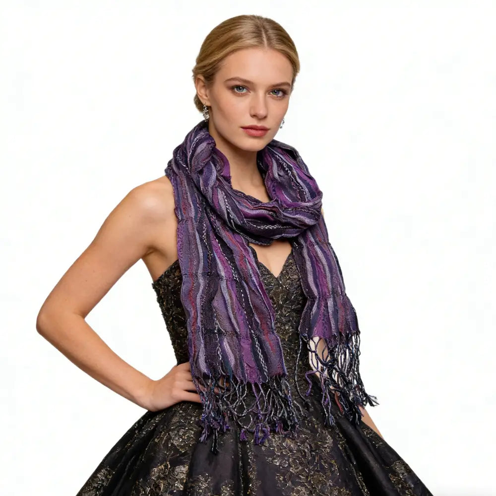 Une écharpe froissée en jacquard, rayée et luxueuse, aux tons violet et noir, avec une trame texturée et des bords frangés, idéale comme accessoire d’hiver.