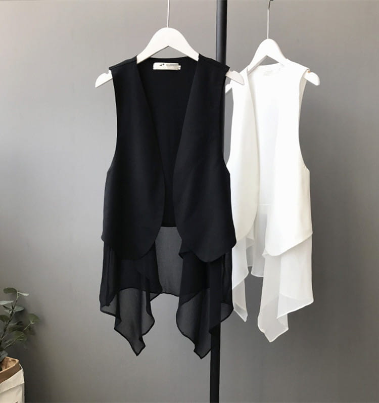 Schwarze und weiße transparente Chiffon-Lagenröcke mit asymmetrischer Passform, ärmellos, auf weißen Bügeln hängend.