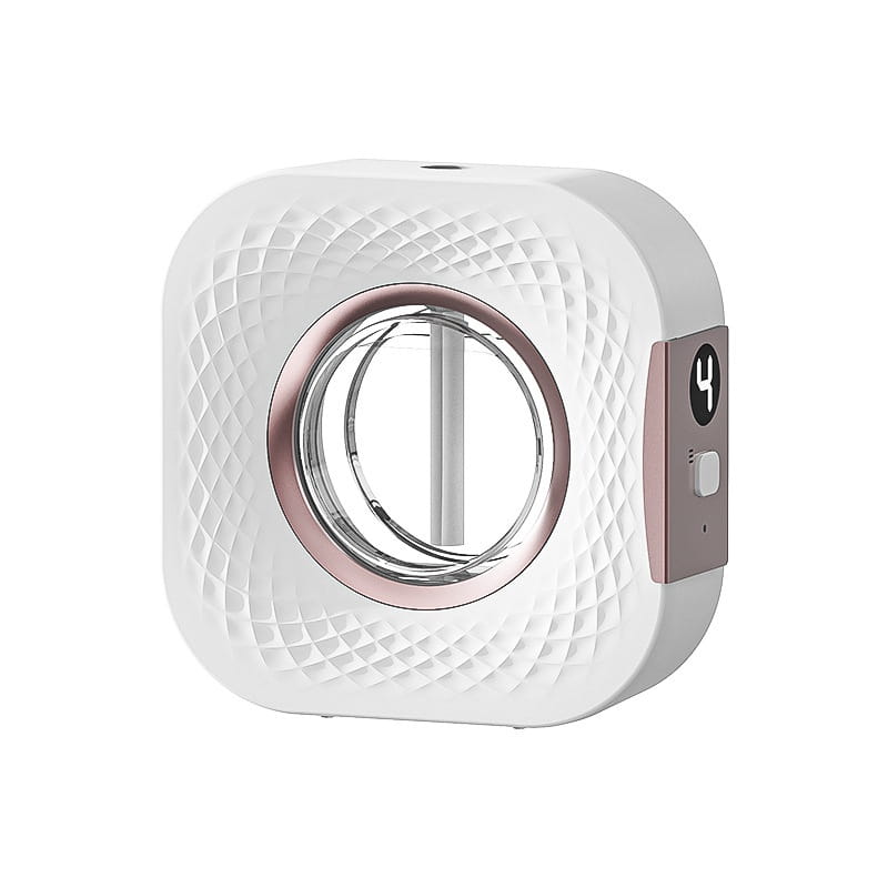 White square-shaped facial cleansing device with diamond-patterned textured surface, rose gold circular frame around the central transparent opening, and a side control panel with power button for the aroma diffuser smart rechargeable wall mounted dispenser.