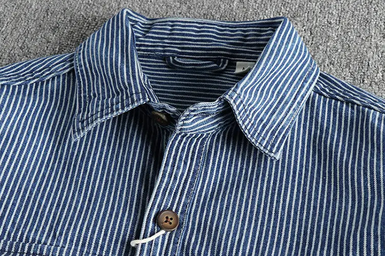 A navy blue and white vertically striped denim shirt for men featuring a classic collar and brown wooden buttons.
