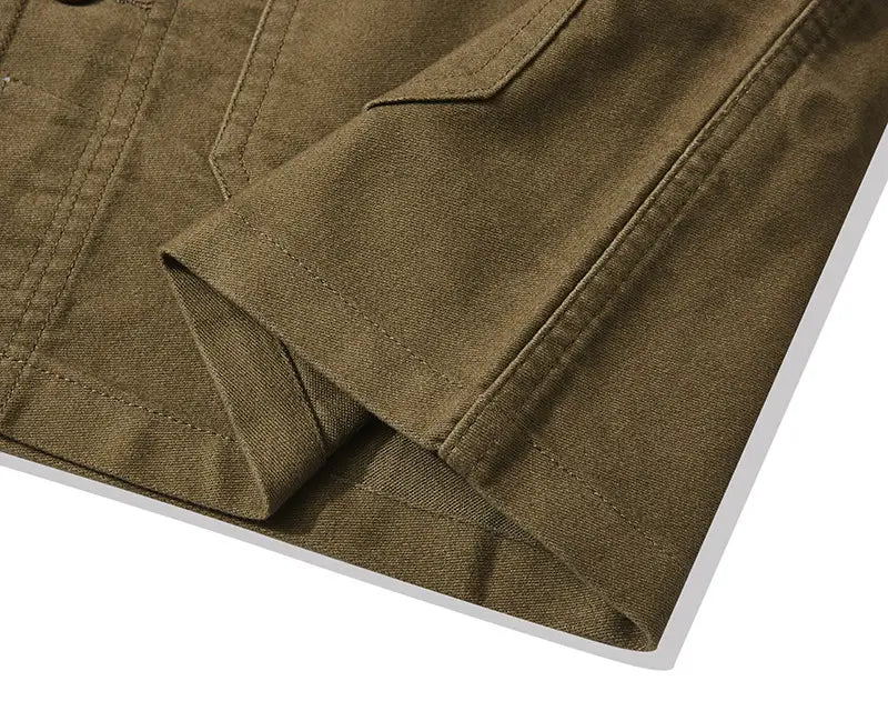 mens french workwear jacket in olive green cotton with visible stitching and a folded sleeve featuring utility pockets.