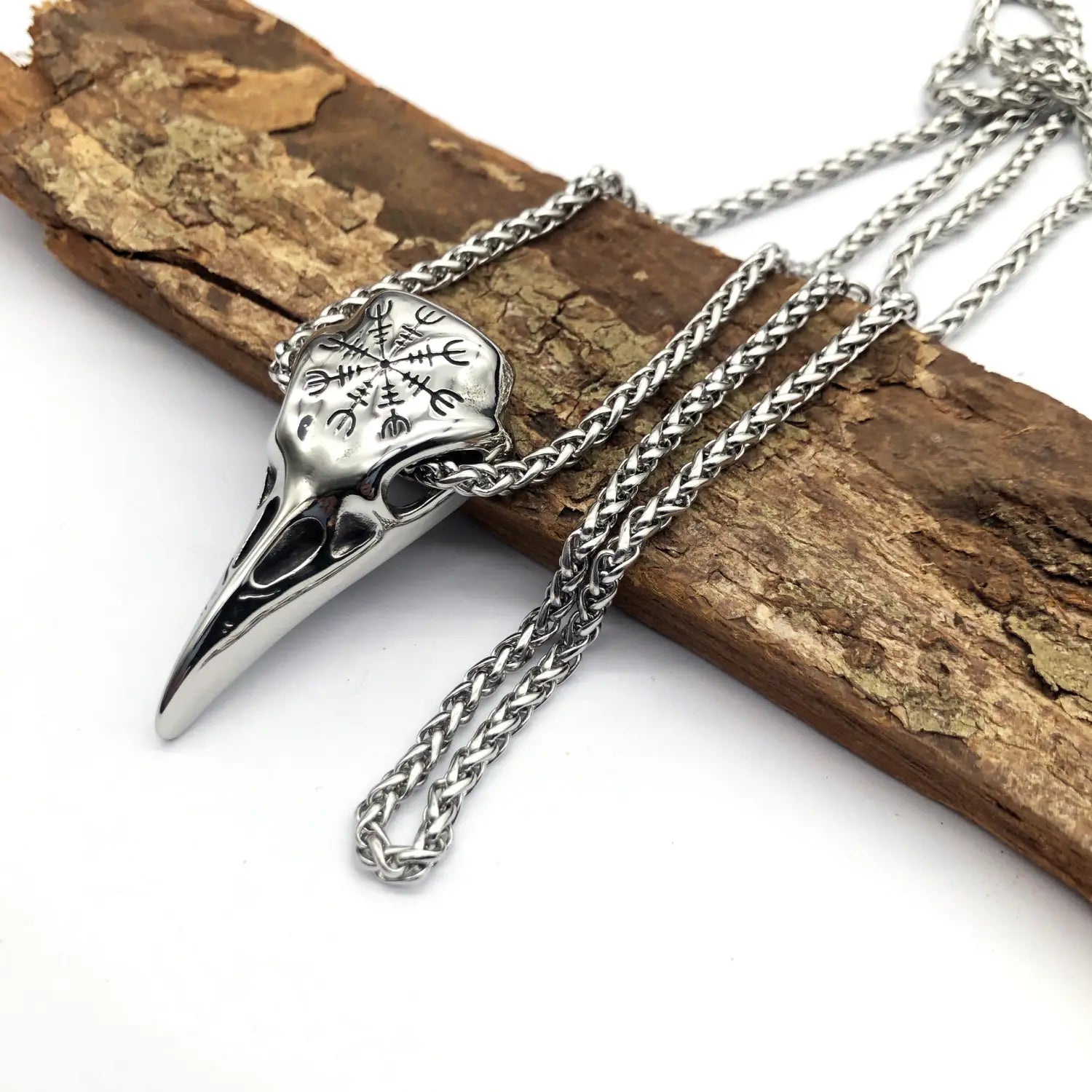Silver vintage viking runic raven skull pendant necklace with engraved runes on a braided stainless steel chain.