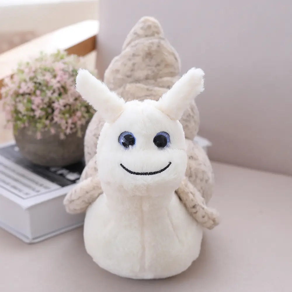 A plush white snail toy with blue eyes and a smiling face made of soft fabric material featuring a textured beige shell is shown.