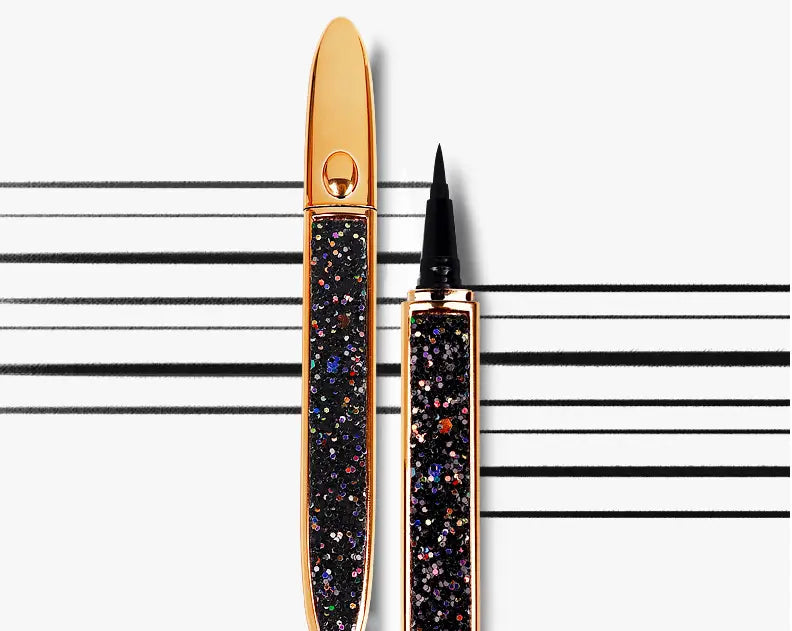 Gold-toned self-adhesive eyeliner pen with a sparkling black glitter body and fine tip, featuring an elegant oval-shaped cap for waterproof false lashes.