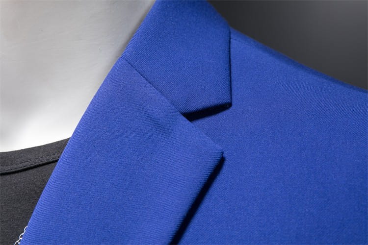 Chaqueta de vestir empresarial de pana azul real vibrante con ajuste slim, cuello a medida estructurado y textura de tejido suave.