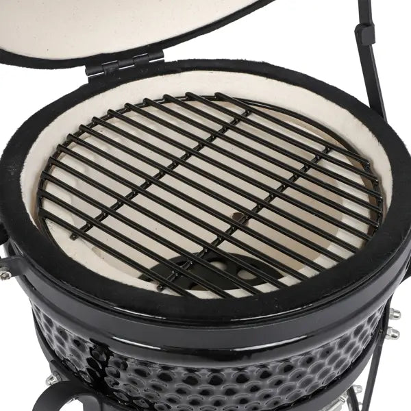 Black ceramic 13 inch kamado charcoal grill with white interior and metal grates.