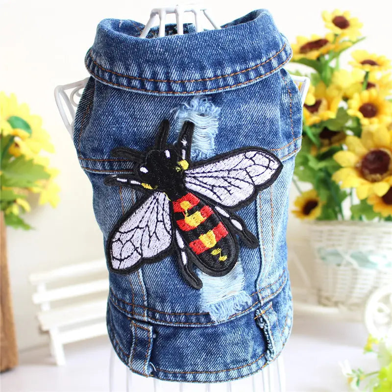 Blue denim dog vest with a prominent embroidered bee patch featuring black yellow and red stripes from the Denim Dog Jacket Strawberry Embroidery Puppy Vest collection.