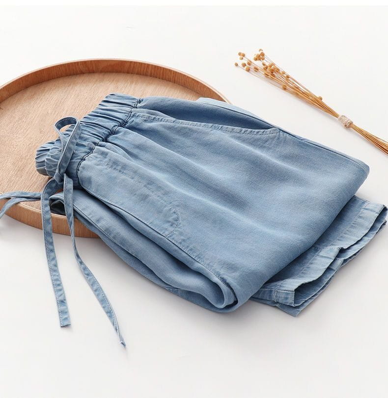 Light blue denim harem jeans with a high waisted elastic waistband and drawstring for adjustable comfort.