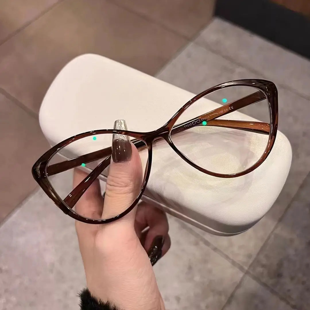 Lunettes de soleil œil-de-chat brunes avec une monture translucide brillante, offrant une protection UV380 légère pour la mode et la sécurité solaire.