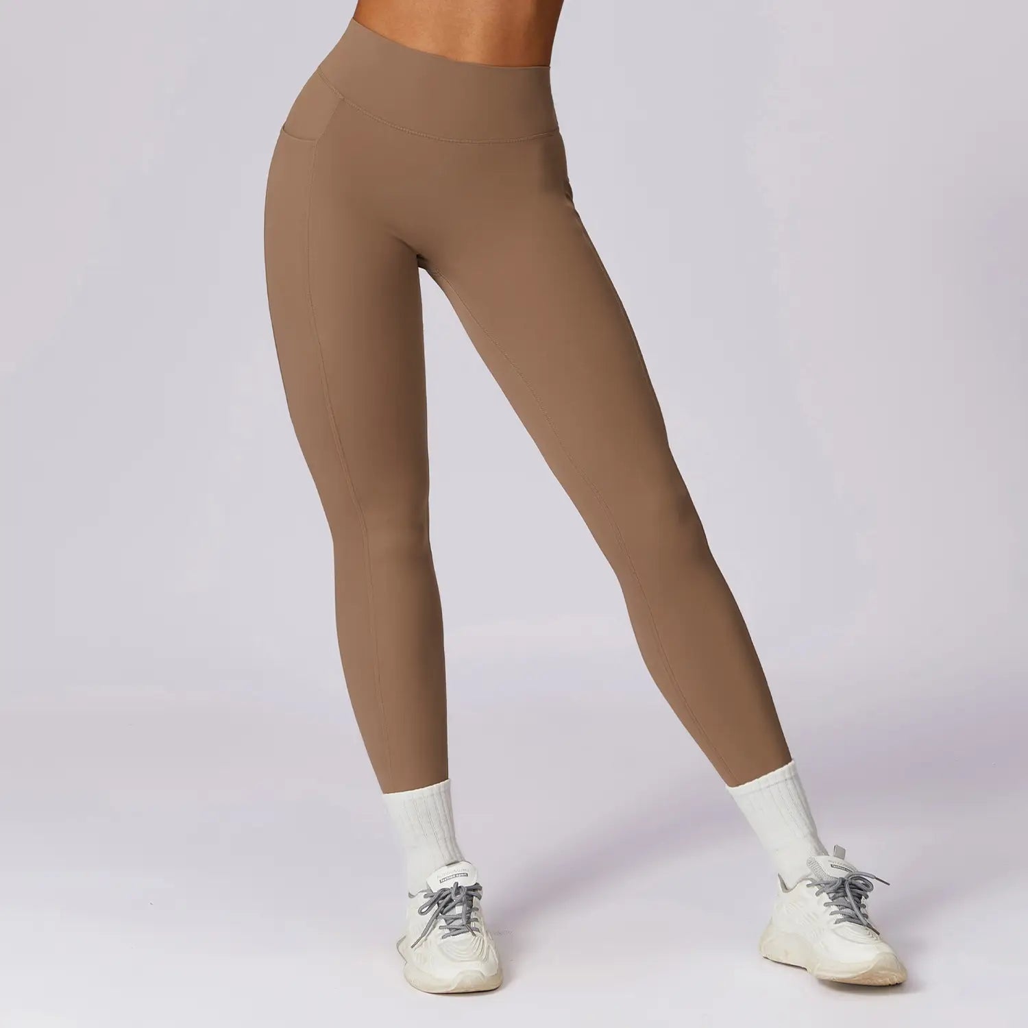 Elite high waisted athletic leggings in tan feature a smooth stretchy fabric designed for optimal comfort and performance.