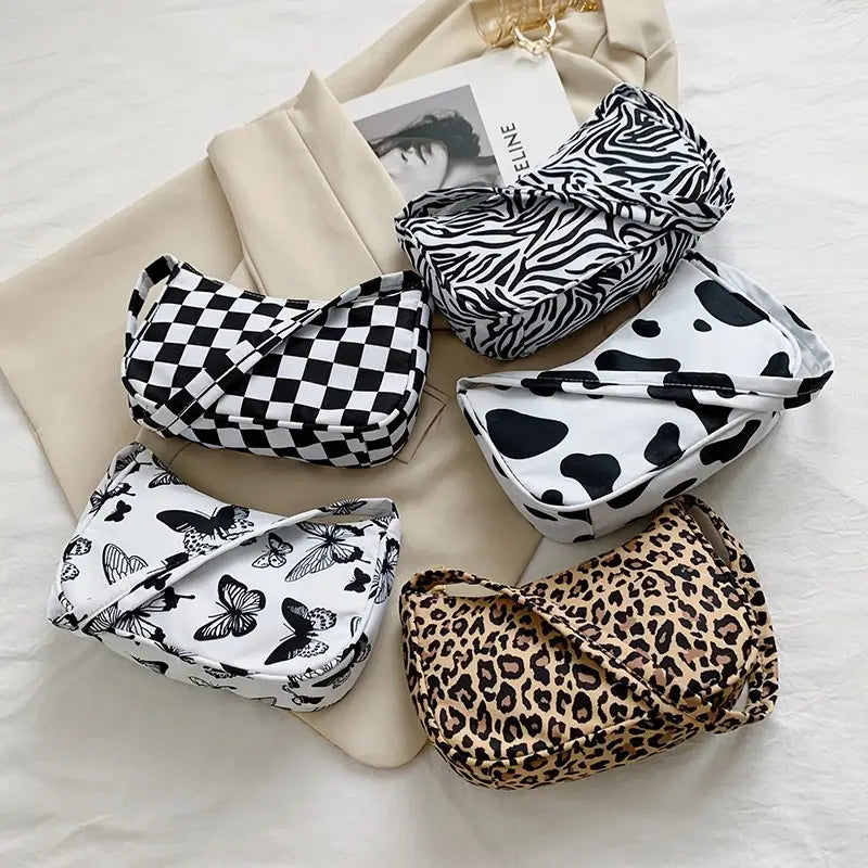 Cinq sacs bandoulière tendance, comprenant des sacs sous-bras en nylon à imprimé léopard et à carreaux, dans des motifs noir et blanc, avec des motifs de zèbre, d’imprimé vache et de papillon.