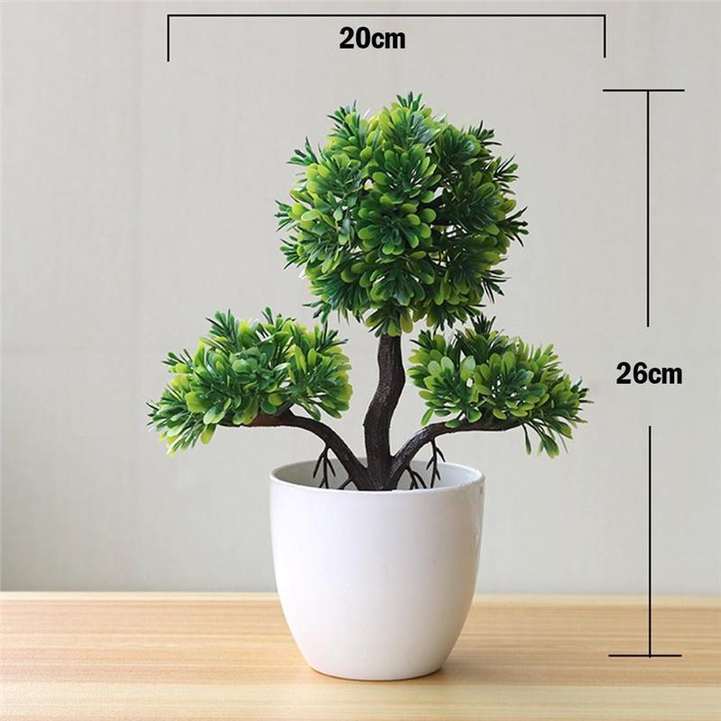 Ein kompaktes künstliches Bonsai-Bäumchen mit üppigem grünem Laub und einem dunkelbraunen Stamm in einem schlichten weißen Keramiktopf.