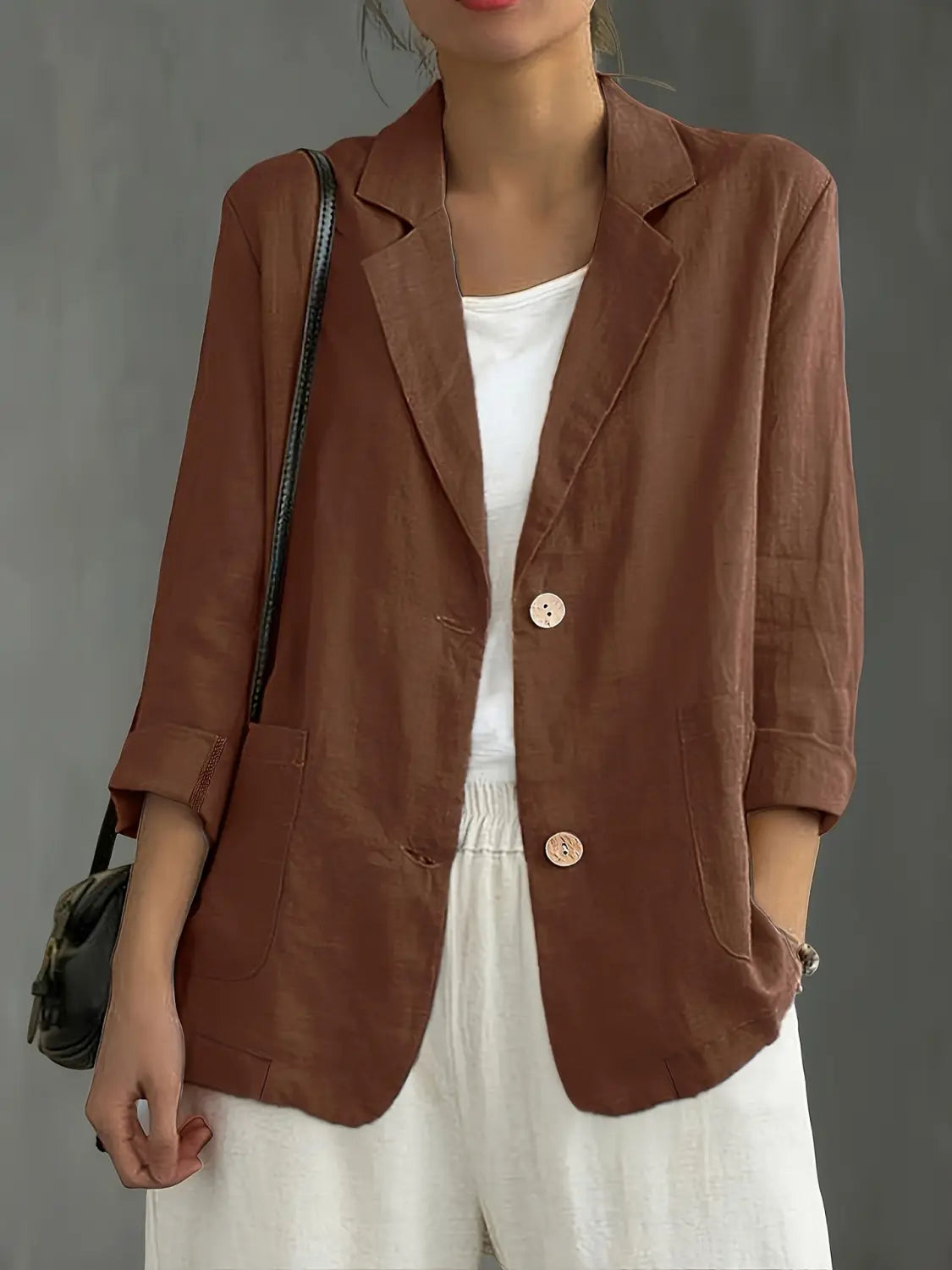 Blazer de lino color marrón para mujer con dos botones delanteros y mangas remangadas, diseñado para ropa de trabajo casual.