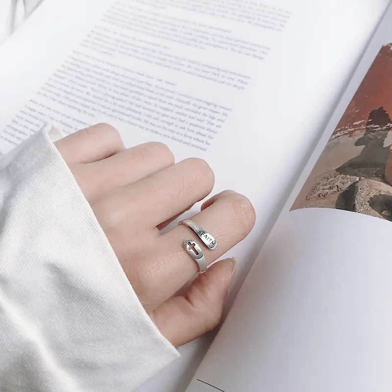 Silver faith cross wrap ring with adjustable band featuring a silver cross and the word faith engraved on the band.
