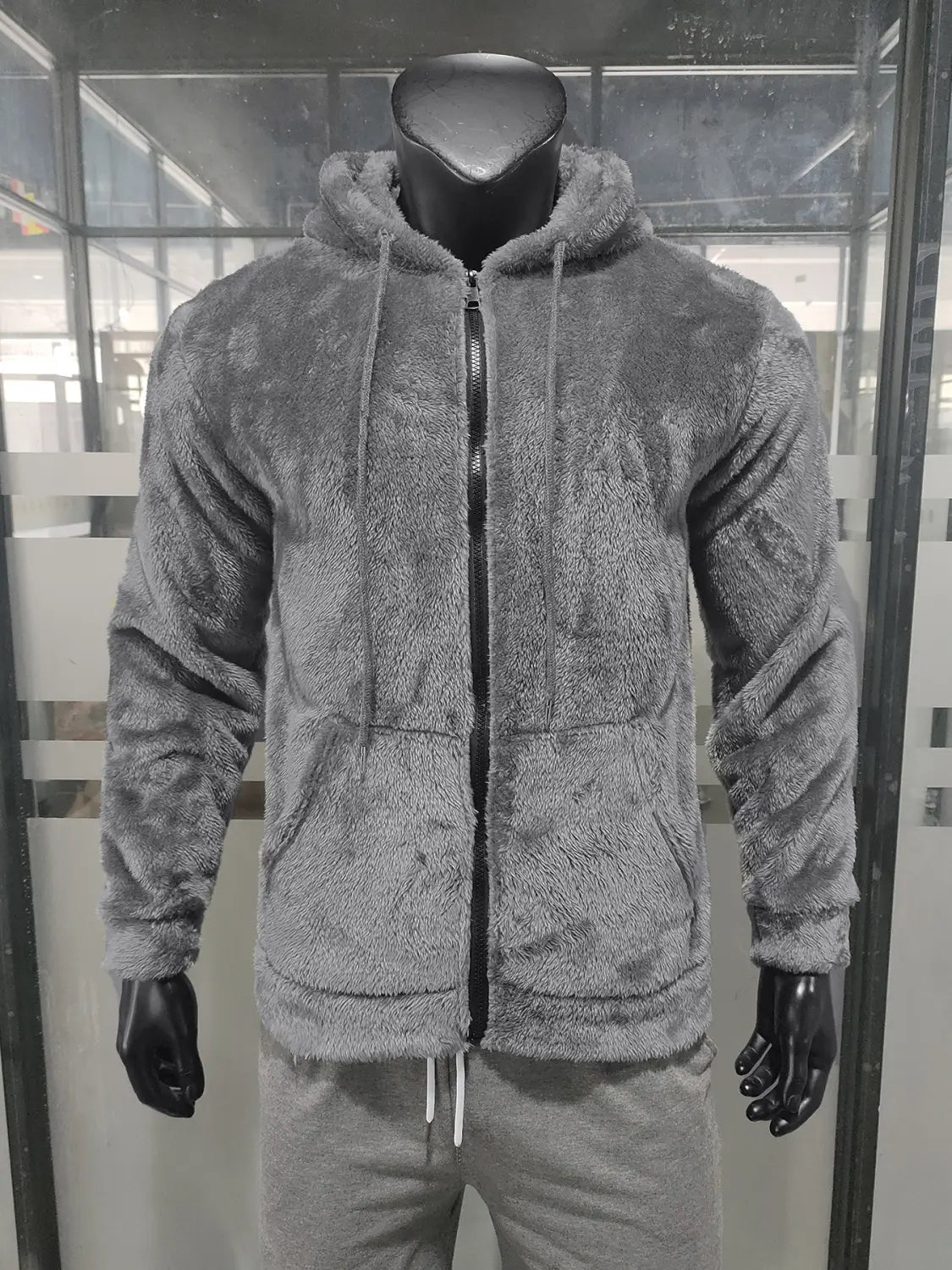 Gray plush fleece lined men’s zip up hooded jacket with drawstrings and front pockets designed for loose fit and comfort.