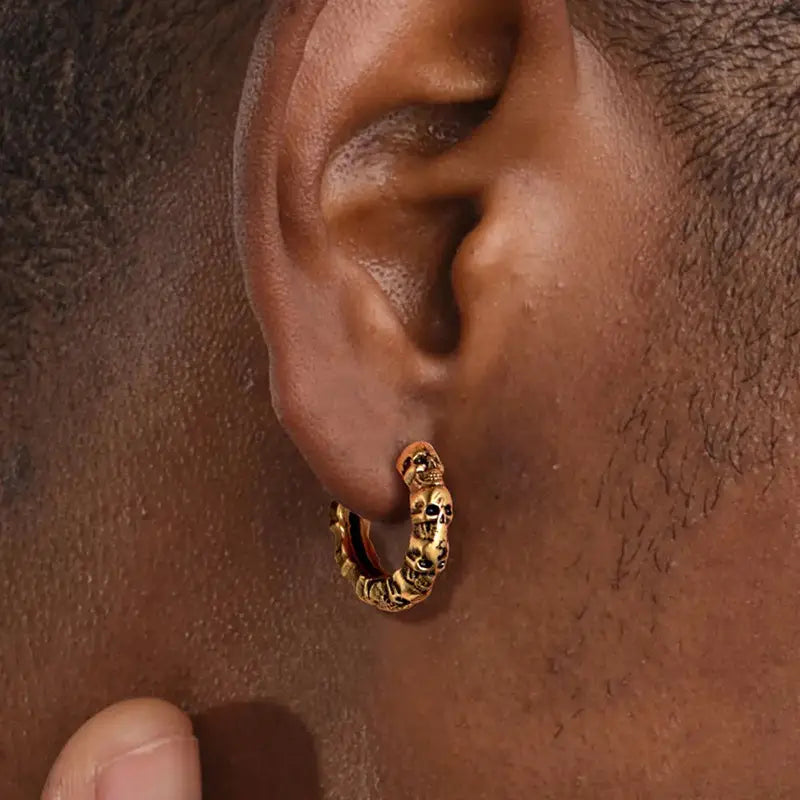 Unisex vintage textured skull hoop earring in gold tone with intricate detailing.