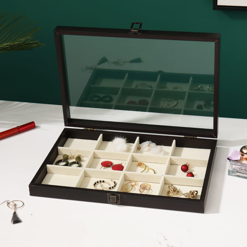 Rosewood jewelry display box with glass lid featuring a black wooden exterior and cream-colored interior compartments.