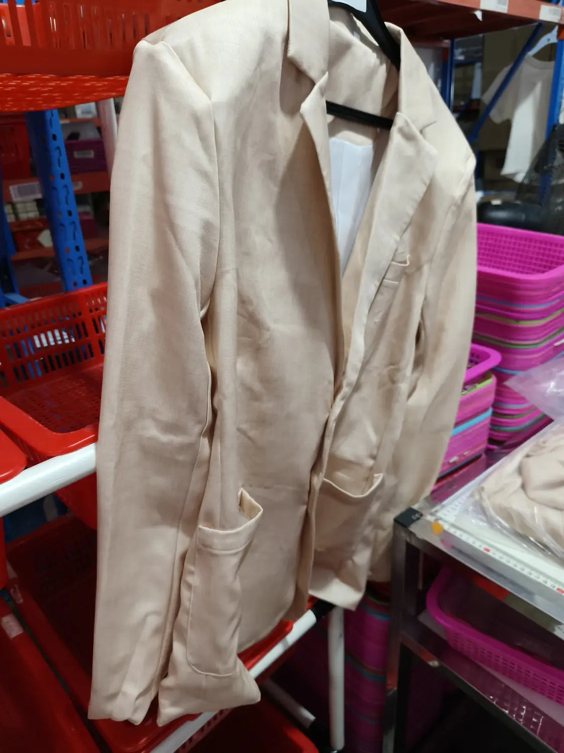 Beige blazer with a classic double-breasted design and two front pockets hanging on a black hanger in a men casual digital print suit two piece set.