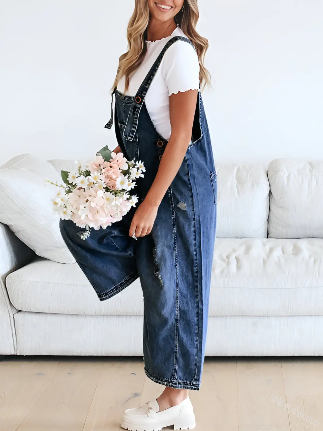 women’s blue denim overalls with distressed details and adjustable straps made of durable denim material