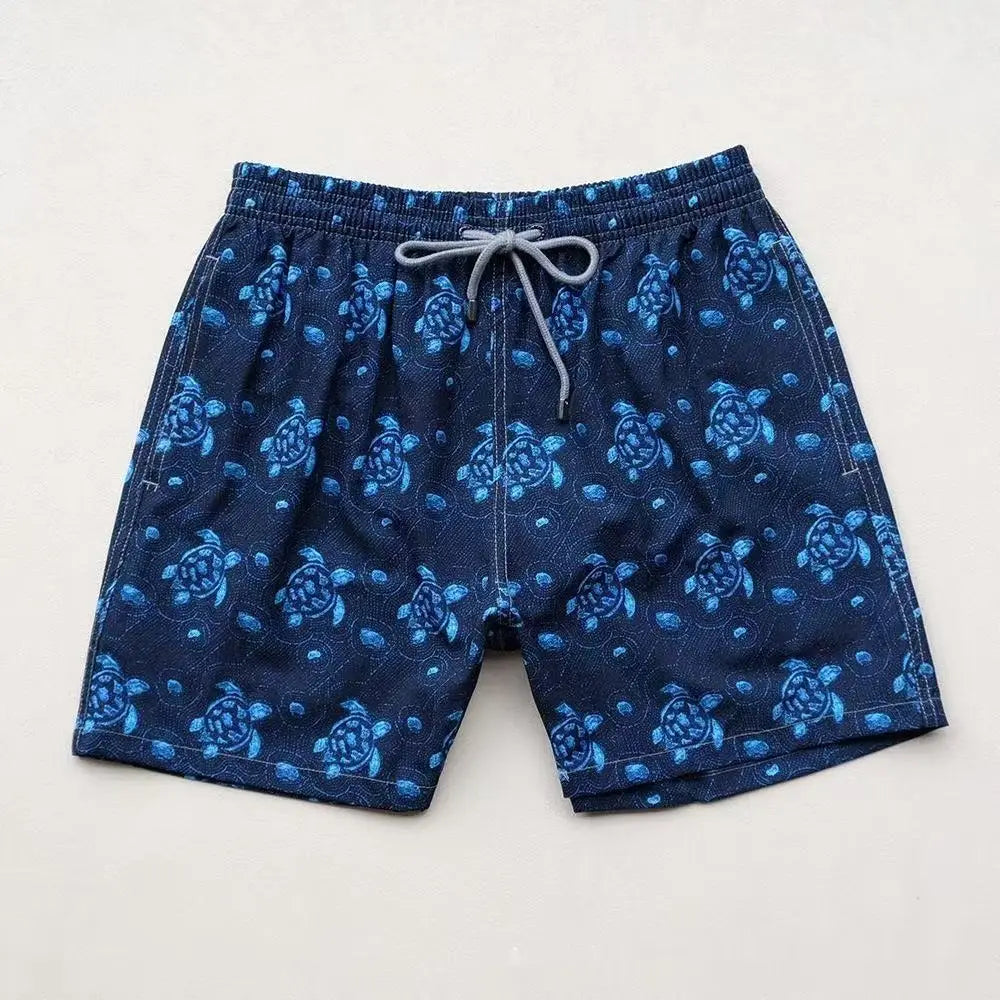 dark blue quick drying beach pants featuring a repeating pattern of lighter blue sea turtles suitable for swimwear.