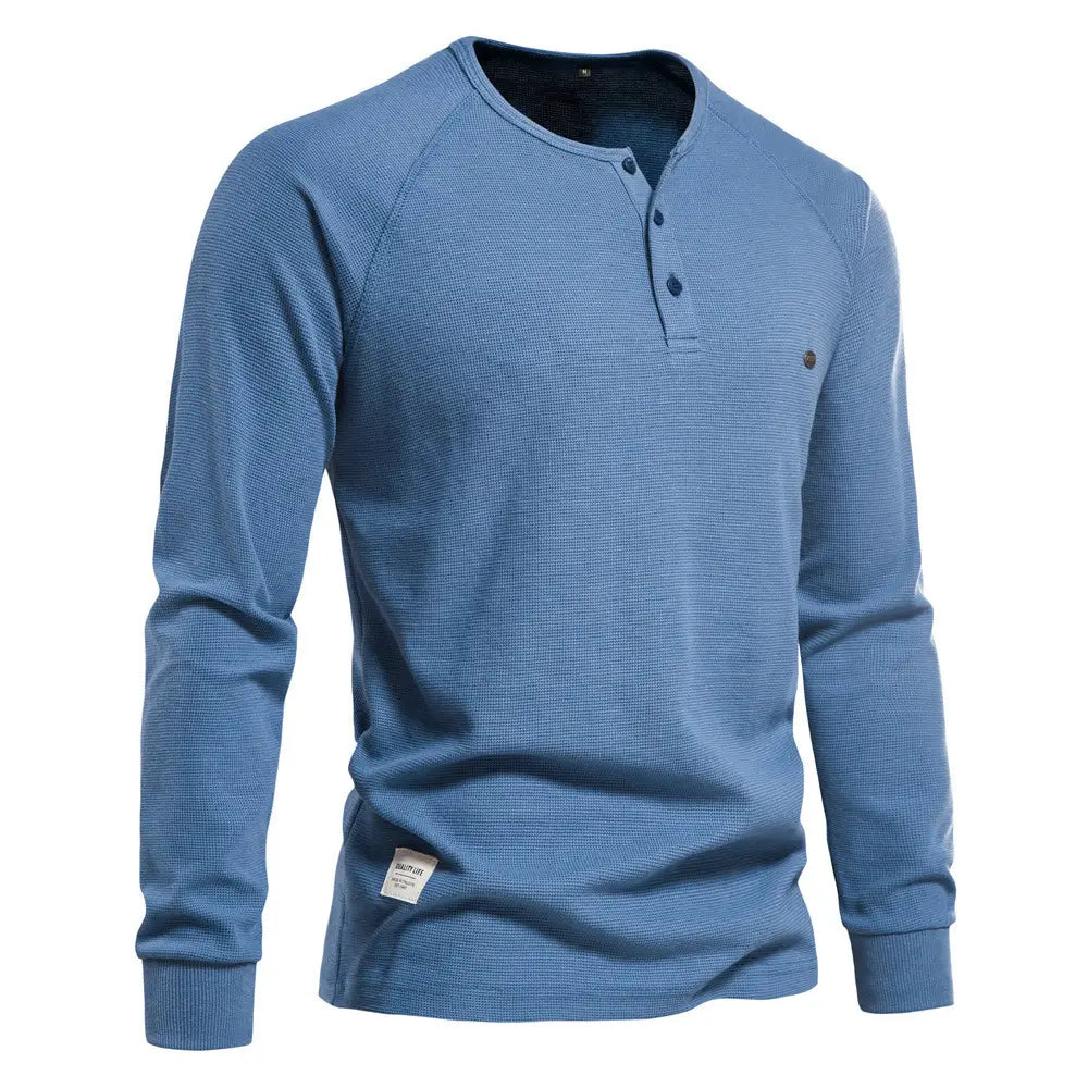 Chemise henley à manches longues côtelée pour homme, de couleur bleue, présentant un motif tricoté gaufré texturé et des boutons bleu foncé.