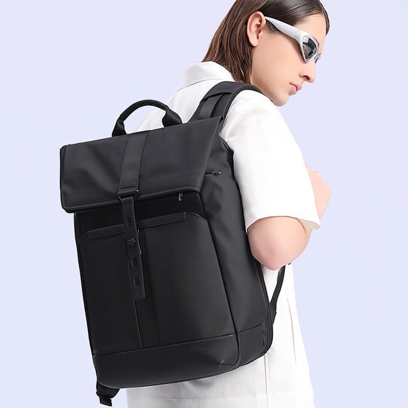 Black nylon business backpack with roll-top closure and front zippered pocket designed for large capacity 30 liters.