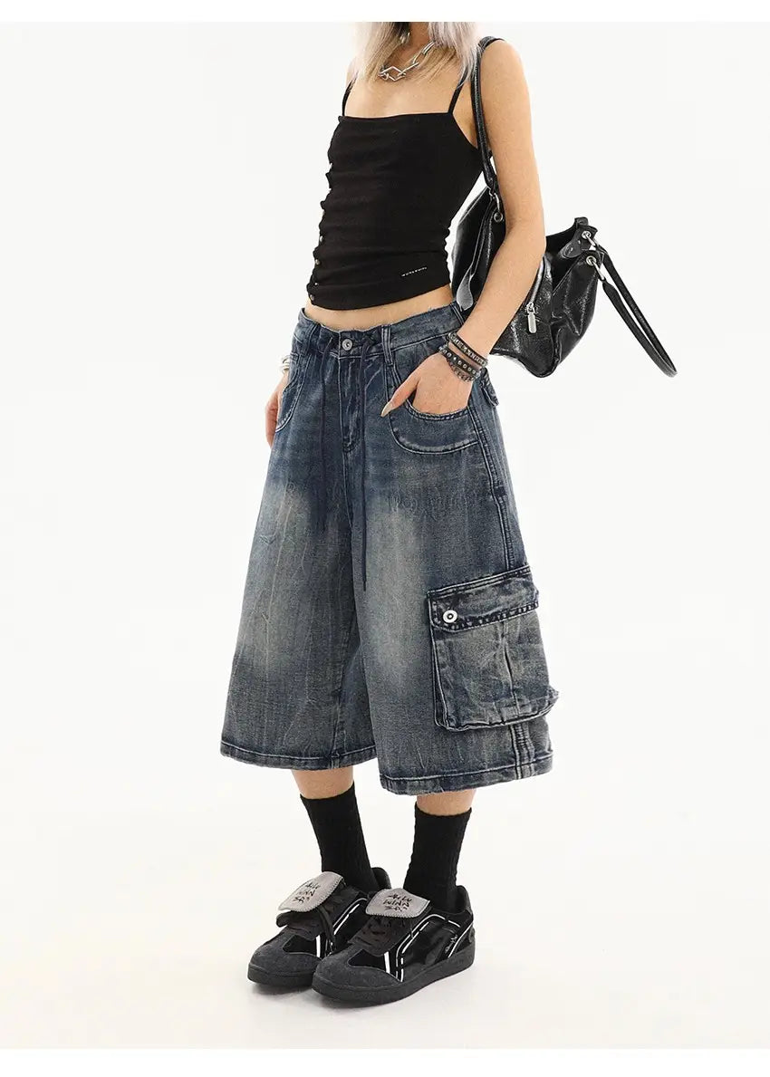 Pantalones cargo de mezclilla azul de pierna recta de estilo urbano, con shorts de mezclilla de pernera ancha en un lavado azul desvaído, múltiples bolsillos cargo y costuras reforzadas.