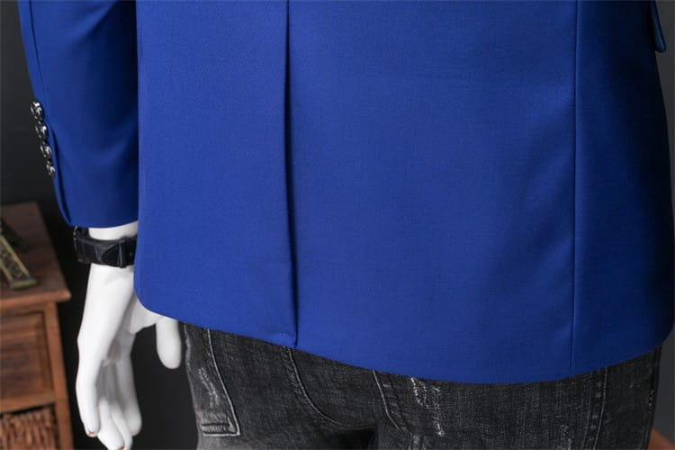 Chaqueta de vestir empresarial de pana azul real vibrante con ajuste slim, diseño estructurado y elegante, y plisado sutil mostrado desde el lado posterior.