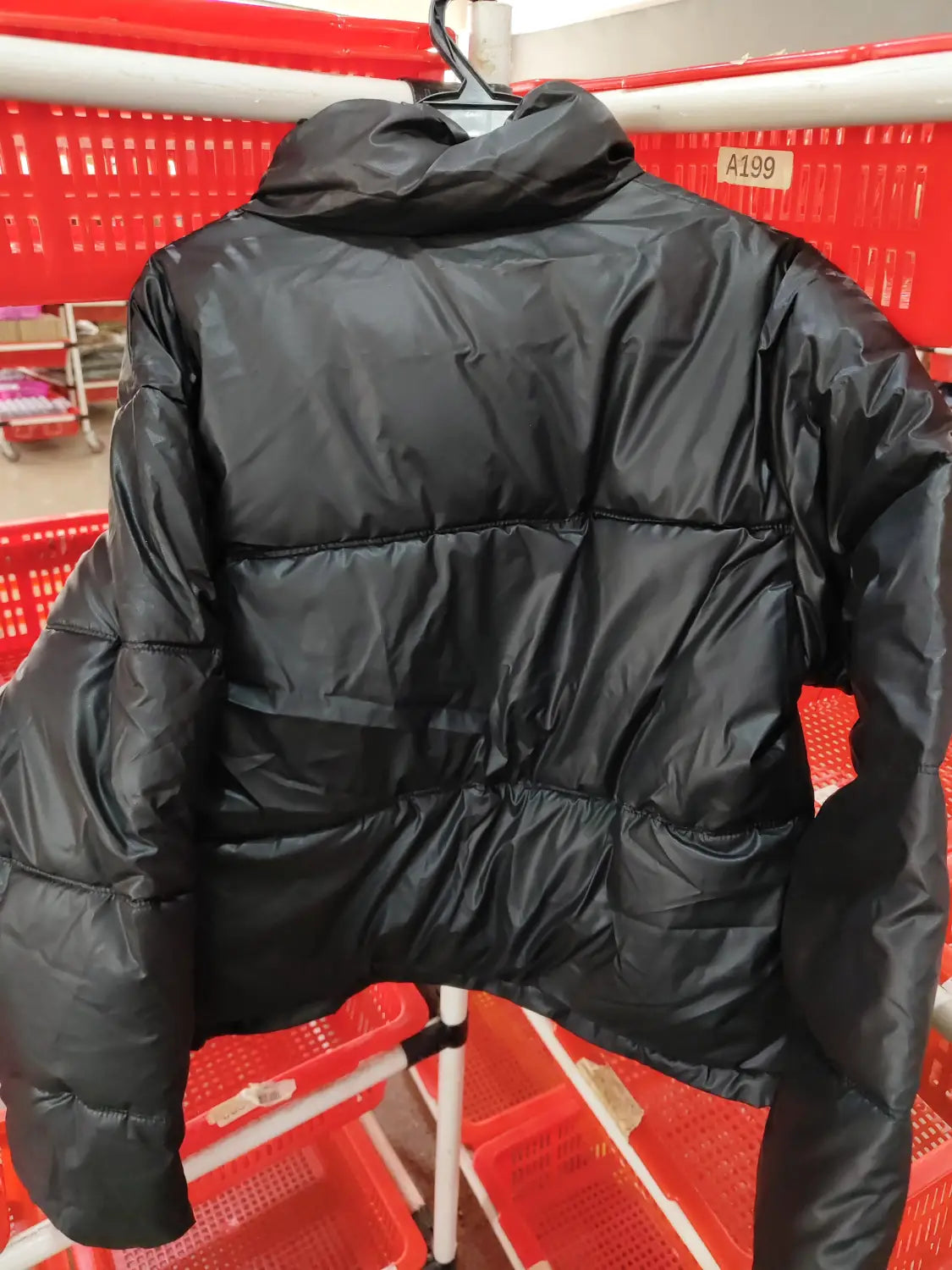 Black women’s quilted puffer jacket with a shiny exterior and a high collar