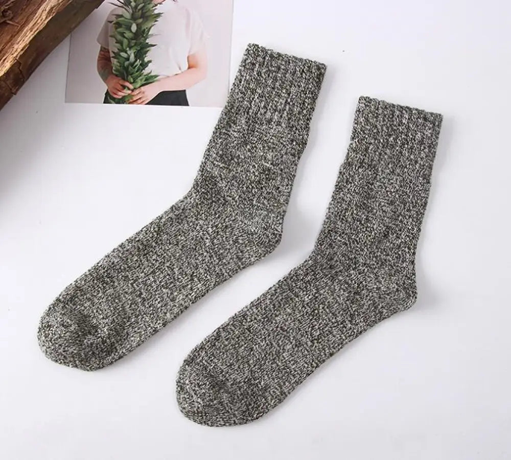 A pair of men’s rabbit fur winter socks in heather gray with a textured knit and ribbed cuff.