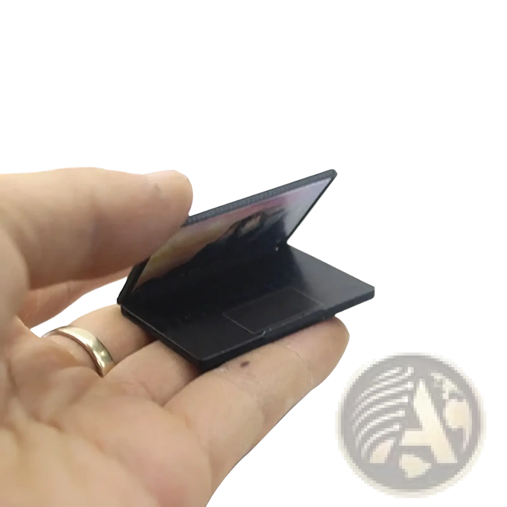 Black miniature laptop dollhouse accessory with sleek glossy finish in 1:12 scale compact design