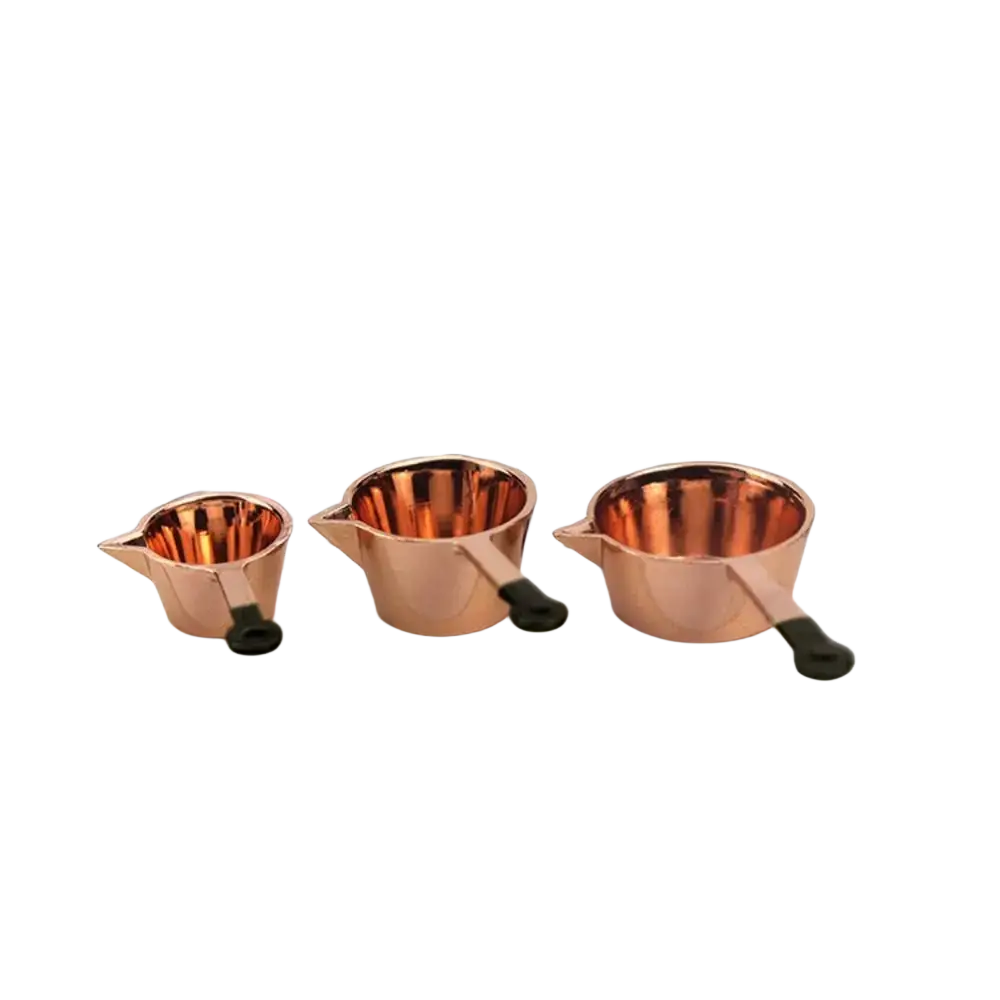 Set of three miniature copper measuring cups with black handles in ascending size for 1:12 dollhouse kitchen use