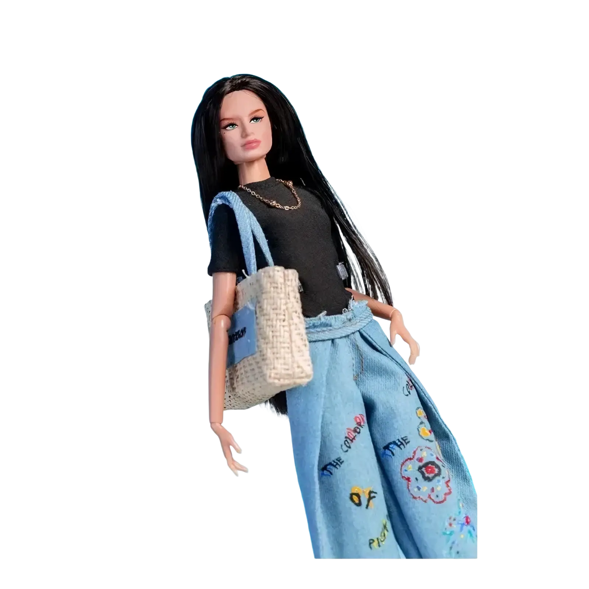 Barbie doll with long black hair wearing a black top and denim pants with colorful embroidered designs in 1/6 scale set