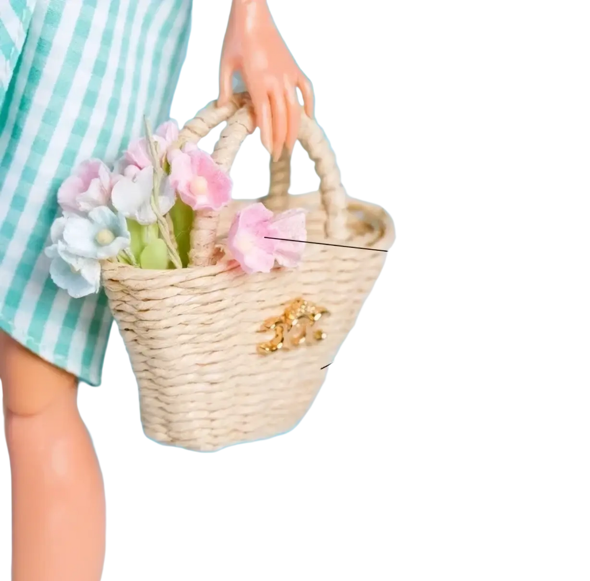 A beige woven straw tote bag with a gold-tone clasp holding pink and white paper flowers for 1/6 scale dolls