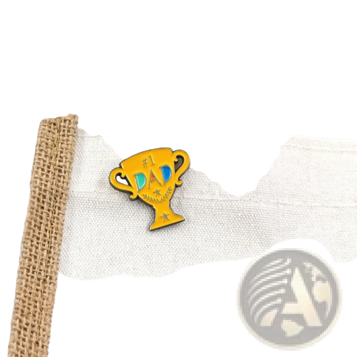 A vibrant yellow enamel pin shaped like a trophy with #1 dad text in blue and black and decorative stars