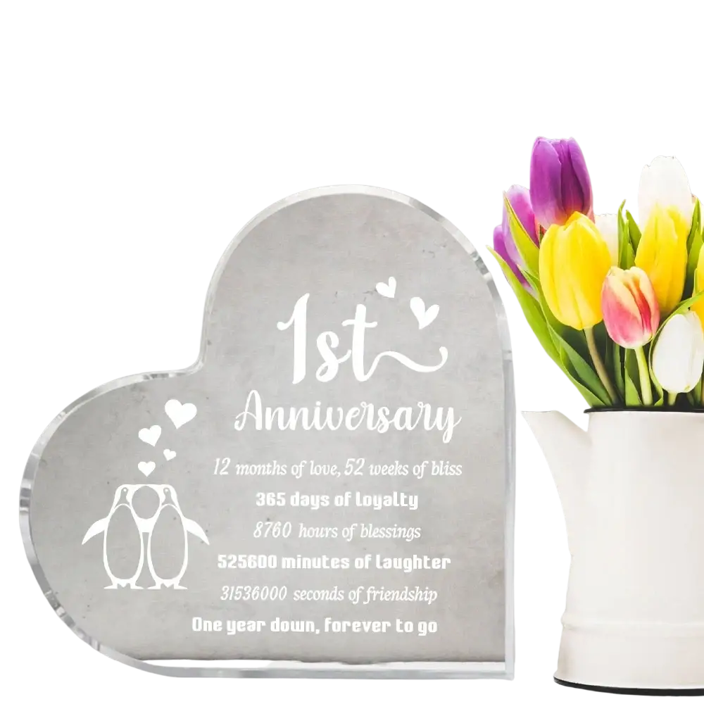 Clear acrylic heart-shaped 1 year anniversary plaque engraved with penguin illustrations and a sentimental love message