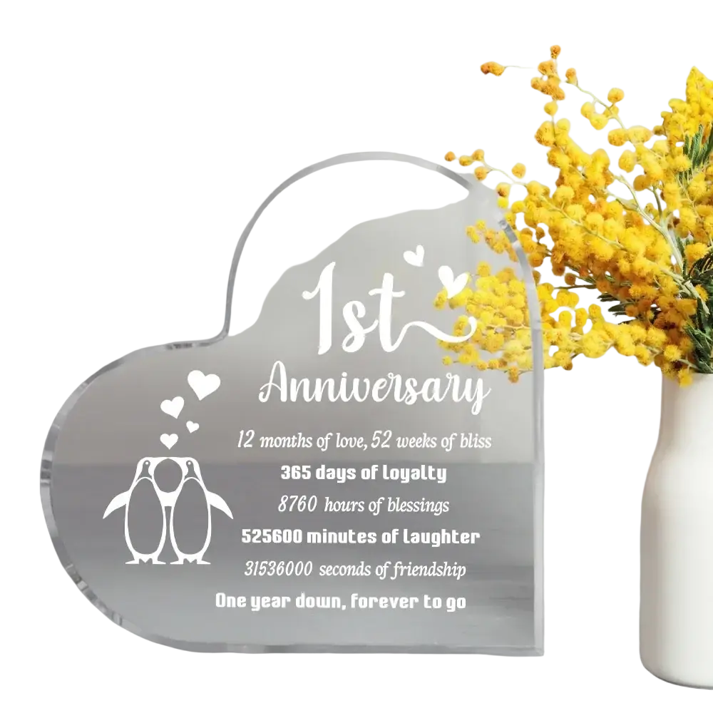 Clear acrylic heart-shaped 1 year anniversary plaque with white engraved text and penguin design