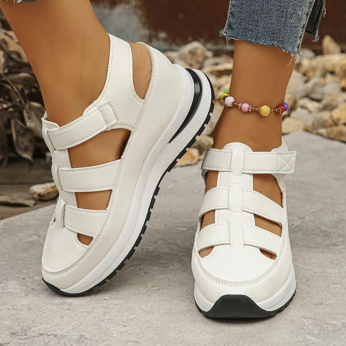 White breathable hollow wedge platform sandals with three adjustable velcro straps and a black rubber sole.