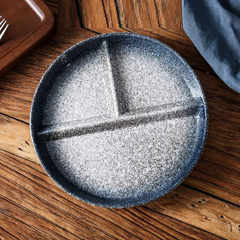 Assiette de dîner divisée en céramique à trois compartiments, avec glaçure à mouchetures bleues et finition mate texturée.