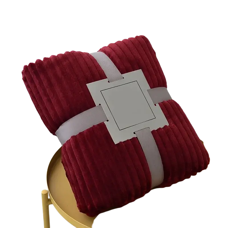 A plush deep red 100x150cm fleece throw blanket made of soft corduroy wrapped with a gray ribbon and tag