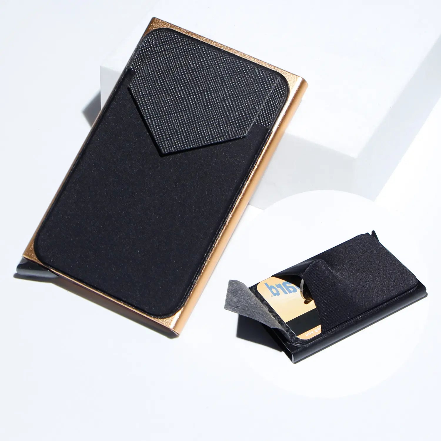 Minimalist RFID blocking aluminum multi card wallet in black and gold with textured black interior lining.