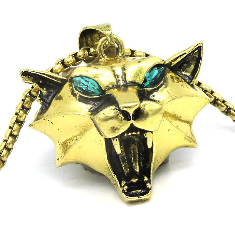 Gold-colored metallic geometric wild game animal pendant chain necklace featuring a roaring panther head with turquoise gemstone eyes and black enamel accents.