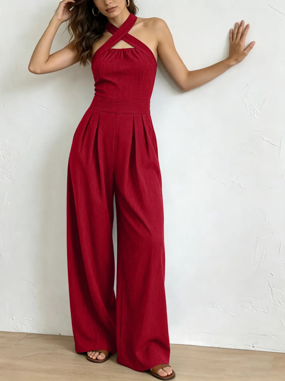 Ein leuchtend roter gerippter Halterneck-Jumpsuit mit gekreuztem Frontausschnitt und Hosen im weitem Bein.