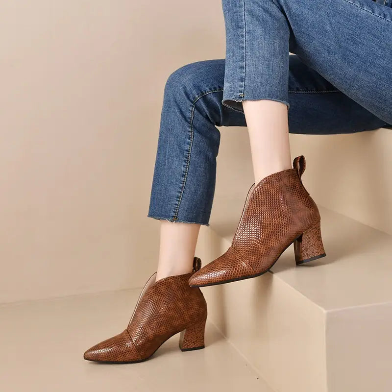 brown snakeskin-patterned ankle boots with a v cut pointed toe and chunky heel.