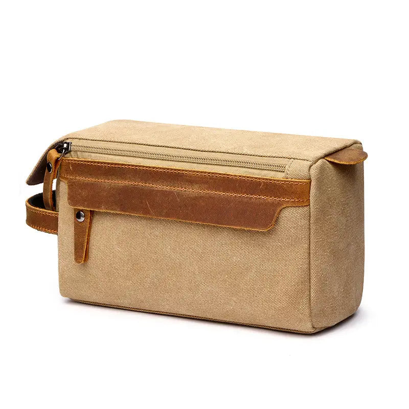 Beige canvas toiletry bag with brown leather accents and zipper closure designed as a large portable travel storage case.