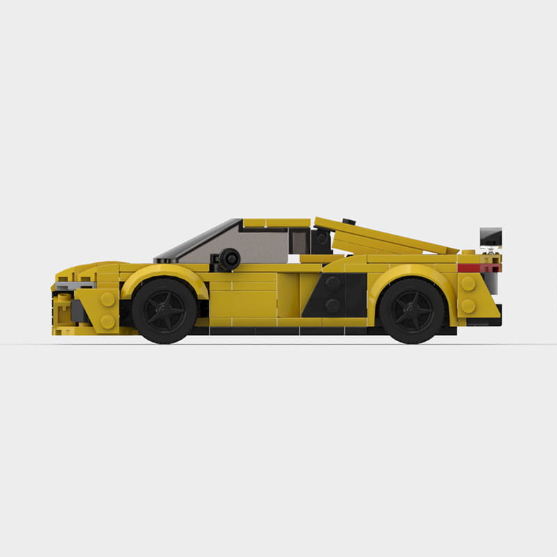 Modelo de automóvil deportivo de lego amarillo con ruedas y detalles negros, diseñado como modelo educativo de bloques de construcción de automóviles de carreras.