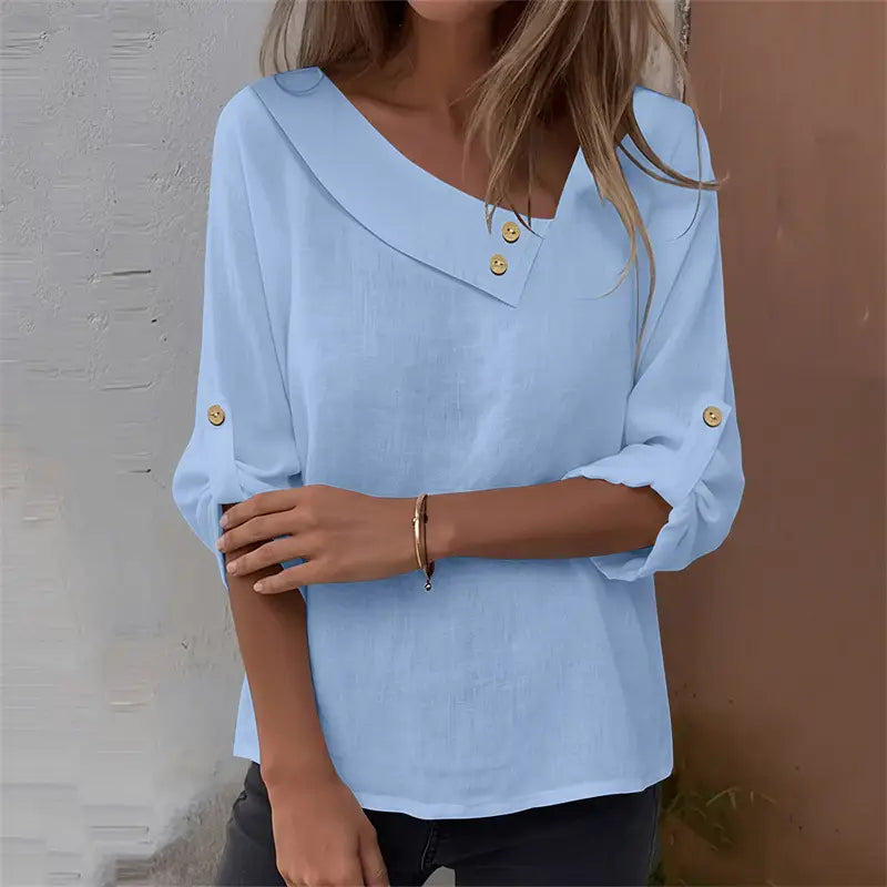 Light blue asymmetric button blouse with a loose fit, collar, and gold buttons.