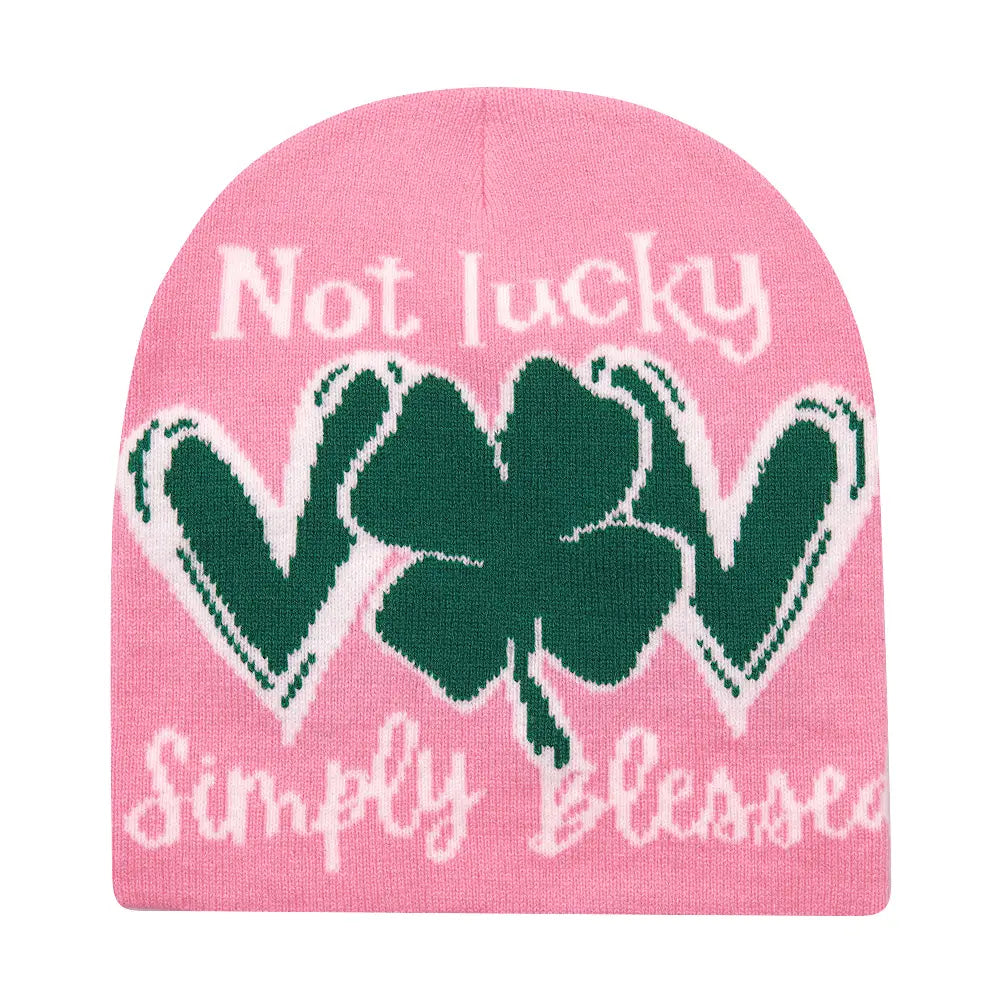 Pink knitted beanie winter warm hat featuring a green shamrock with the text not lucky above and simply blessed below in white lettering.
