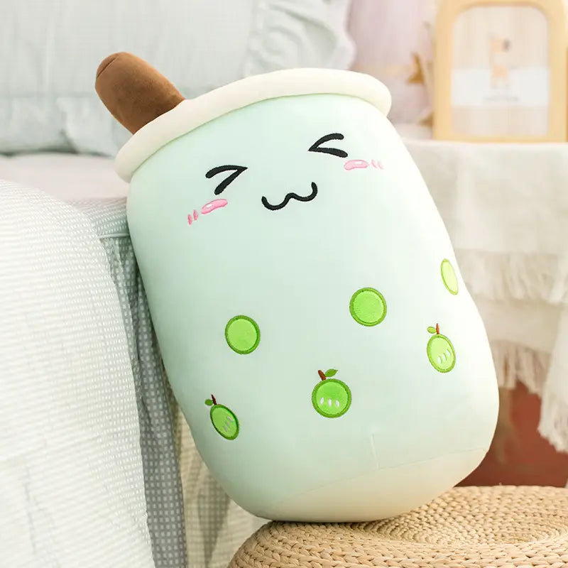 coussin moelleux vert menthe, souple et en forme de tasse de thé aux perles boba, avec des perles de tapioca vertes brodées et des tranches de pomme, dans le design kawaii en lait de thé aux fruits.