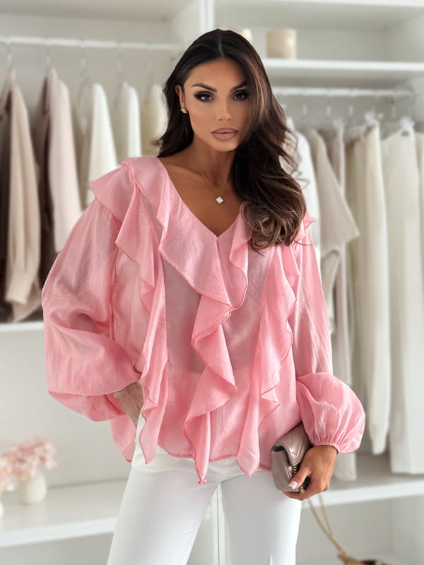 A soft pink sheer ruffled V-neck puff sleeve blouse with voluminous sleeves and layered neckline.